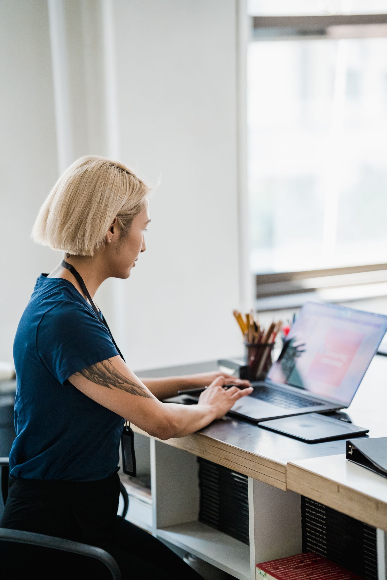 A person working on a laptop in a bright office.